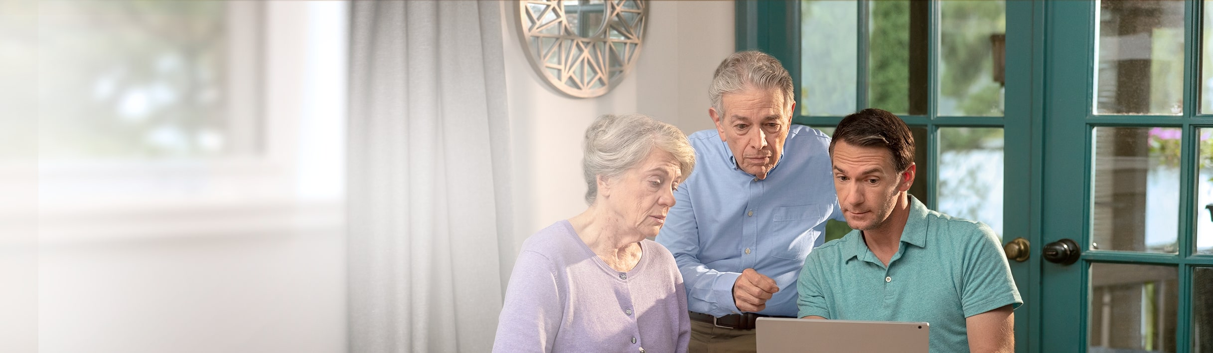 Three people looking at caregiver tips on a computer.