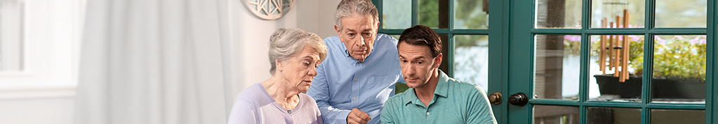 Three people looking at caregiver tips on a computer. Not actual patients.