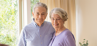 Man and woman smiling at a group.